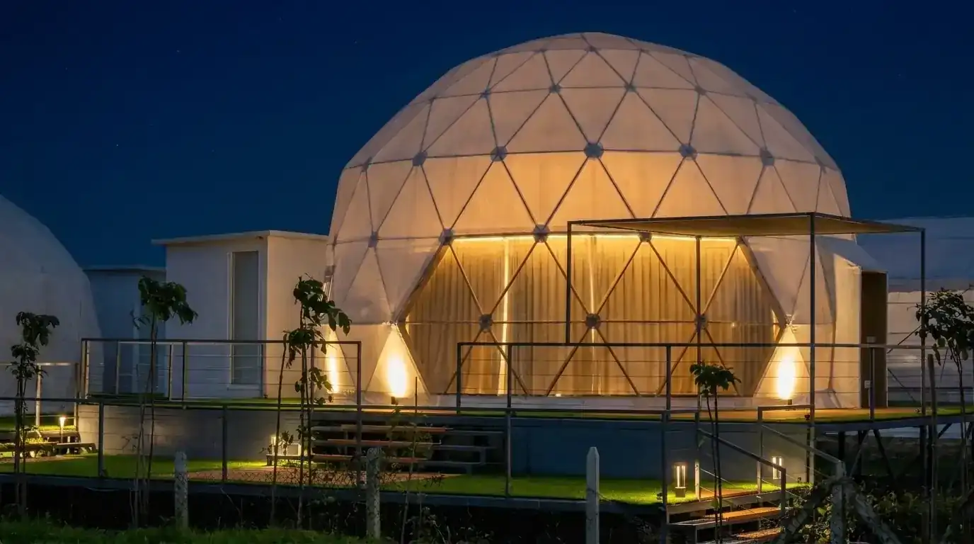A luxury geodesic glamping dome nestled in a lush jungle canopy at golden hour.